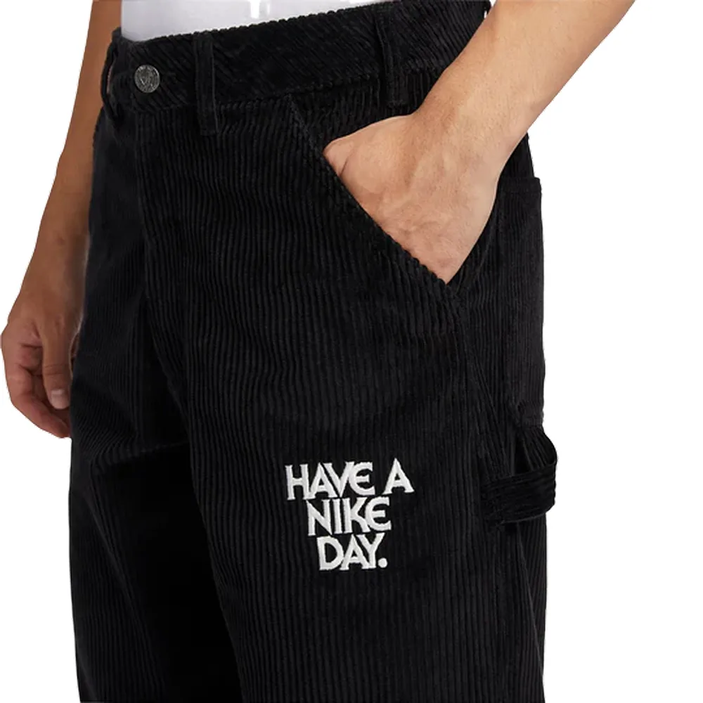 Боковой кадр модели: черный вельвет с четкой текстурой, надпись "Have a Nike Day" и удобный крой. Идеальны для casual-образа