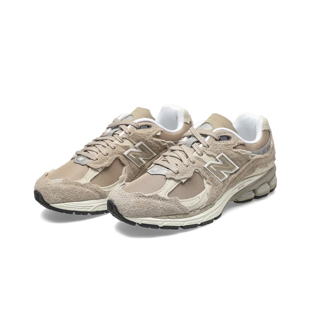New Balance 2002R Driftwood с защитным дизайном. Вид спереди: бежевый верх с потертостями, белые шнурки и логотип N на сетке