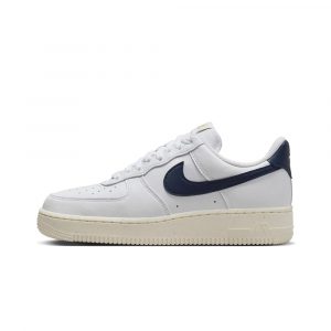 Боковой ракурс: классические белые кроссовки Nike Air Force 1 Low Olympic с тёмно-синими Swoosh и золотыми акцентами, идеальны для олимпийского стиля