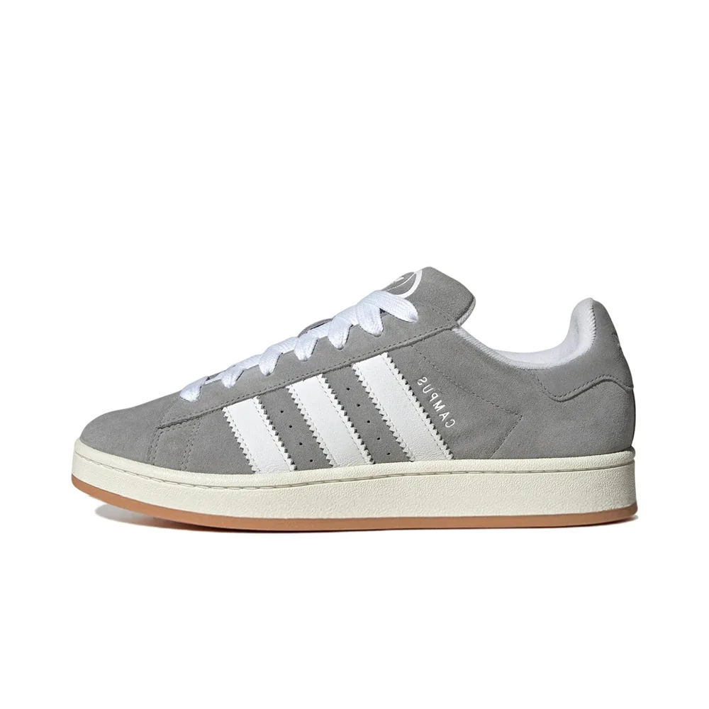 Боковой ракурс: Adidas Campus Grey White с серым замшевым верхом, белыми 3-Stripes и кремовой подошвой. Классический ретро-стиль для casual-образа